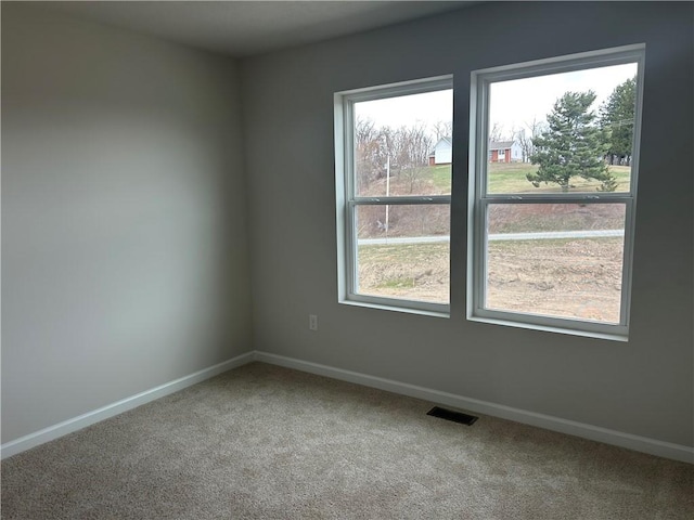 unfurnished room featuring carpet flooring, baseboards, and visible vents