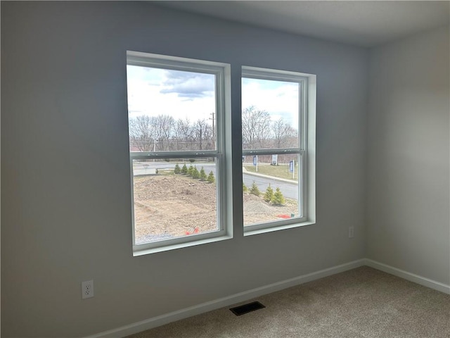empty room featuring visible vents, baseboards, and carpet floors