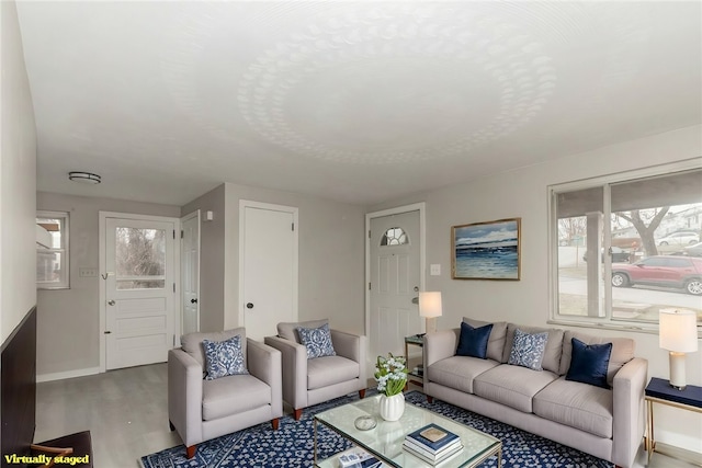 living area with baseboards and wood finished floors