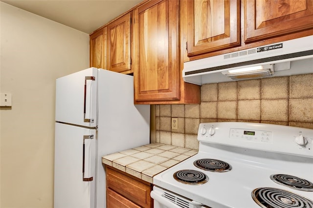 5841 Morrowfield Ave Unit 104, Squirrel Hill, PA 15217 - kitchen with under cabinet range hood, brown cabinets, backsplash, and white appliances