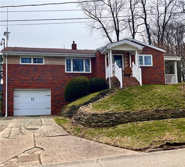 ranch-style home featuring a chimney, driveway, an attached garage, a front yard, and brick siding