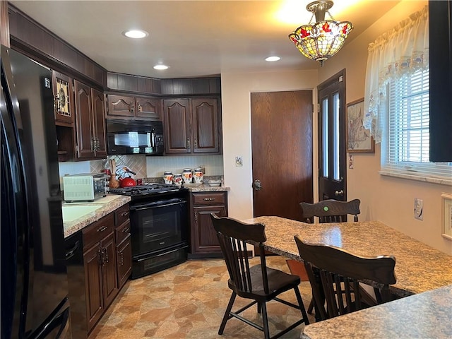 kitchen featuring tasteful backsplash, light countertops, black appliances, and dark brown cabinetry