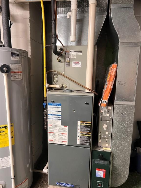 utility room with heating unit and water heater