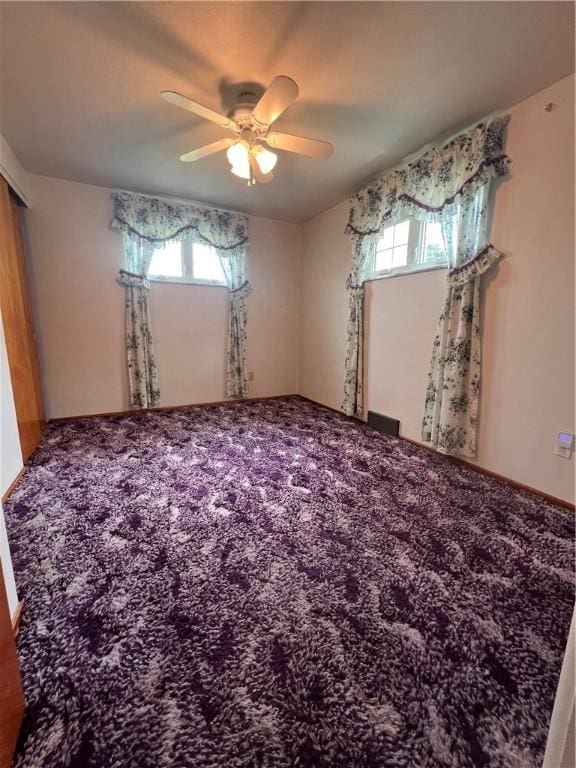 carpeted spare room featuring ceiling fan