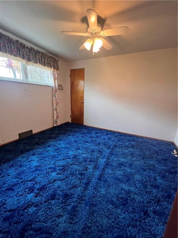 carpeted empty room with ceiling fan