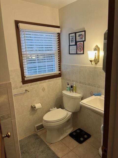 111 Mckenney Dr, Brighton Twp, PA 15009 - half bathroom with tile patterned flooring, visible vents, toilet, tile walls, and a wainscoted wall
