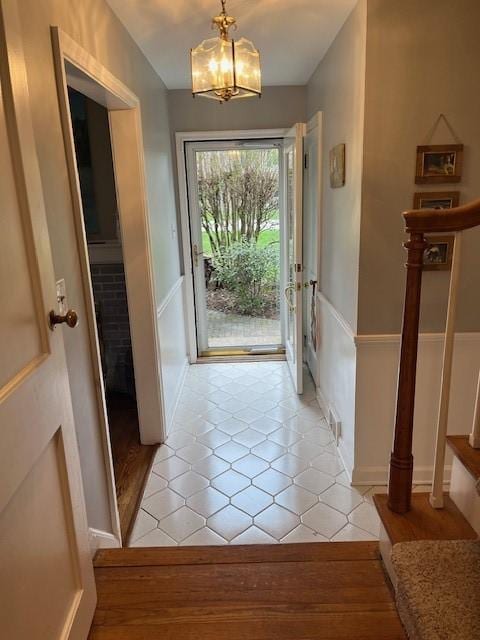 111 Mckenney Dr, Brighton Twp, PA 15009 - doorway to outside with stairway, light tile patterned floors, wainscoting, and a notable chandelier