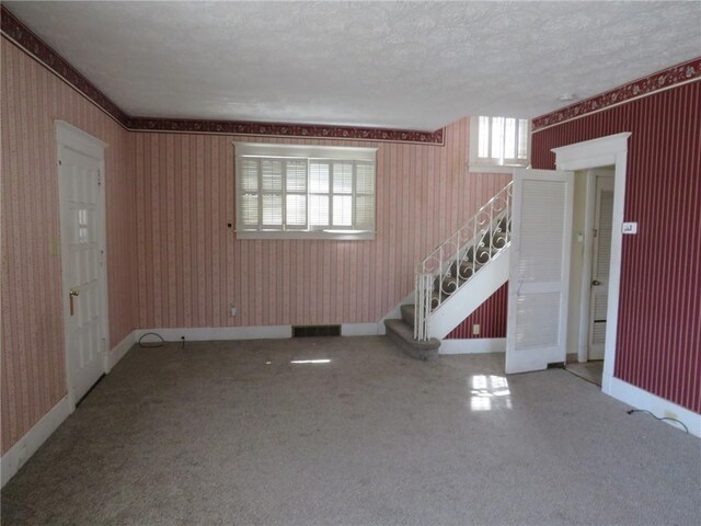 437 Shady Ave, Charleroi Boro, PA 15022 - unfurnished living room featuring stairway, wallpapered walls, carpet floors, and a textured ceiling