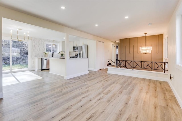 130 Castle, West Mifflin, PA 15122 - unfurnished living room featuring baseboards, light wood-style flooring, recessed lighting, and a chandelier