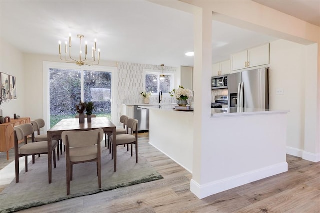 130 Castle, West Mifflin, PA 15122 - dining area with baseboards, light wood-type flooring, and an inviting chandelier