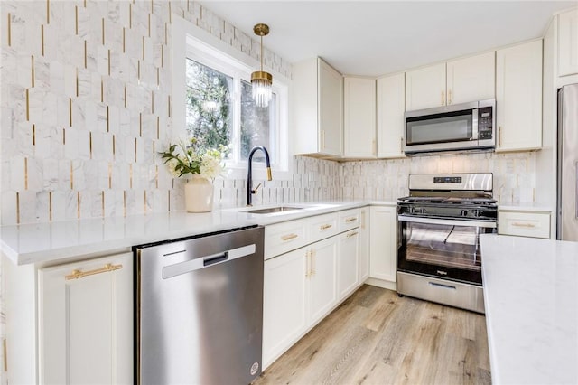 130 Castle, West Mifflin, PA 15122 - kitchen with white cabinetry, light countertops, decorative backsplash, a sink, and appliances with stainless steel finishes