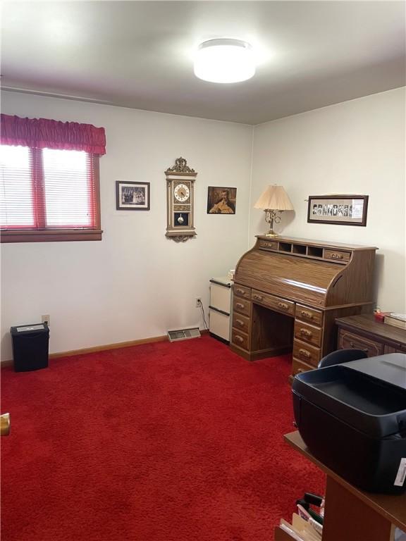 office area featuring visible vents and dark carpet