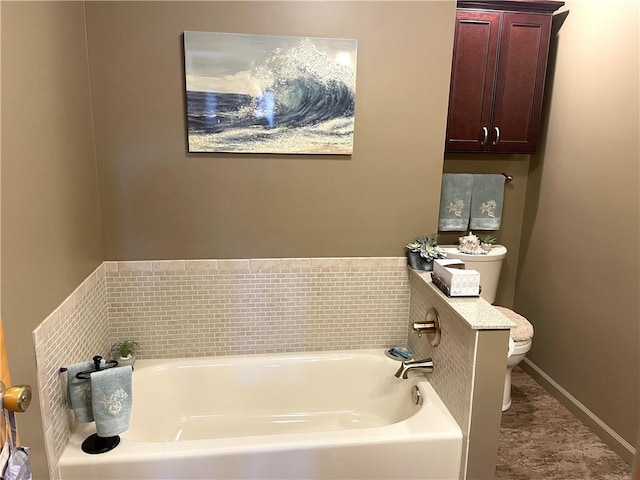 bathroom featuring a garden tub and toilet