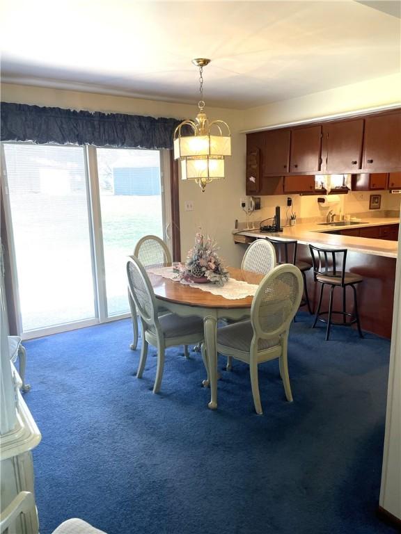 carpeted dining room featuring a healthy amount of sunlight and a sink