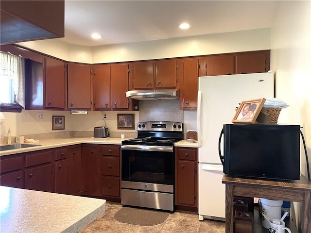 kitchen with a sink, light countertops, under cabinet range hood, and electric range