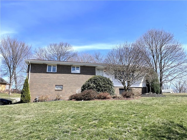 view of property exterior with brick siding and a yard