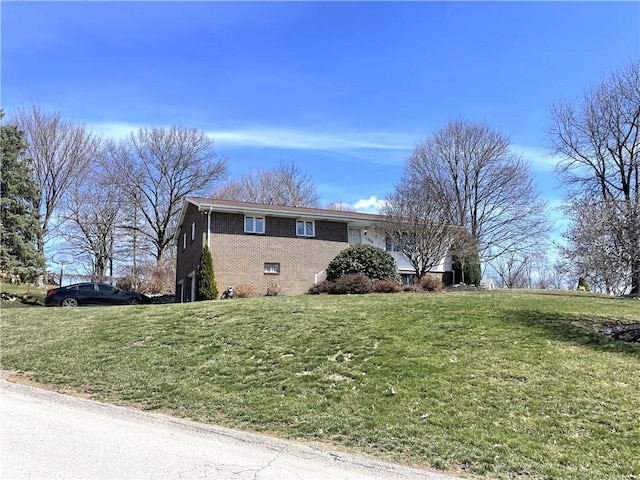 view of side of property with a yard and brick siding