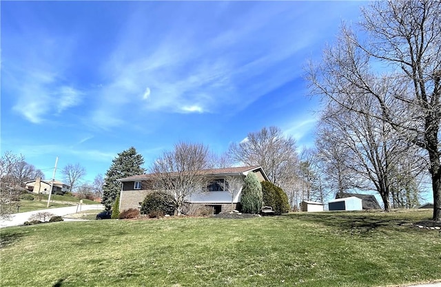 view of property exterior with brick siding and a yard