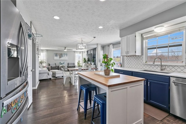 145 Brighton Ln, Adams Twp, PA 16046 - kitchen with appliances with stainless steel finishes, wooden counters, a textured ceiling, a breakfast bar area, and open floor plan