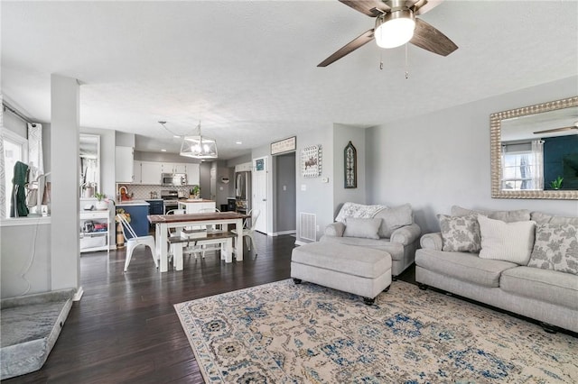 145 Brighton Ln, Adams Twp, PA 16046 - living area featuring a ceiling fan, dark wood-style flooring, baseboards, and a chandelier