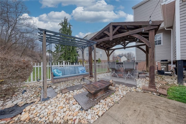 view of patio / terrace with fence, a gazebo, and an outdoor fire pit