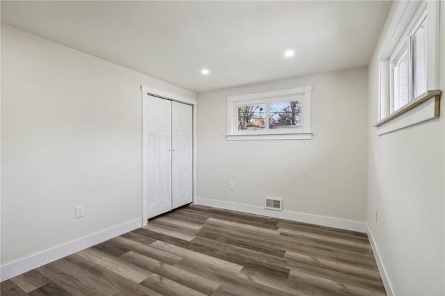 unfurnished bedroom with multiple windows, visible vents, and baseboards
