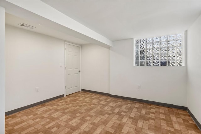 finished below grade area featuring baseboards and visible vents