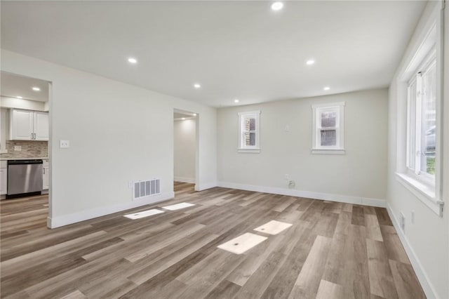 interior space with baseboards, visible vents, and light wood-style floors