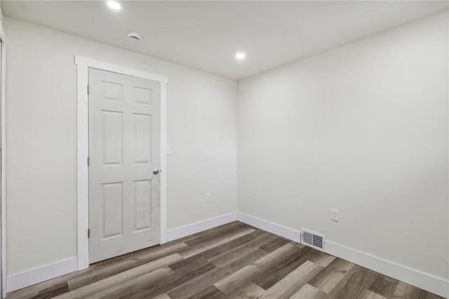 spare room featuring baseboards, visible vents, wood finished floors, and recessed lighting