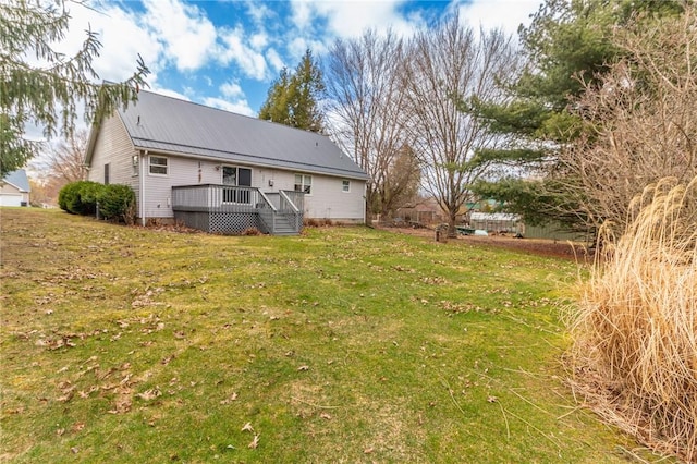 back of house featuring a lawn, metal roof, and a deck