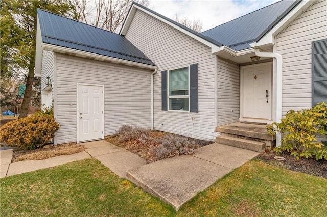 doorway to property featuring a yard and metal roof