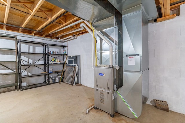 unfinished basement featuring heating unit and concrete block wall