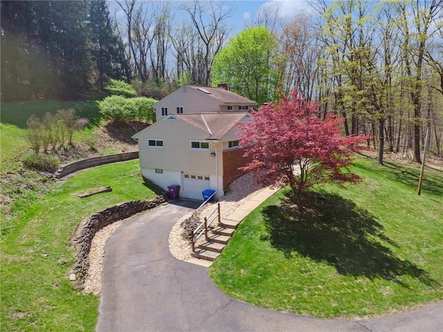 view of home's exterior with a yard, aphalt driveway, and a garage