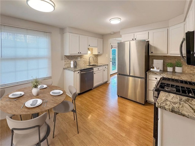 1248 Satellite Cir, Upper St Clair, PA 15241 - kitchen with appliances with stainless steel finishes, backsplash, white cabinetry, light wood finished floors, and light stone countertops