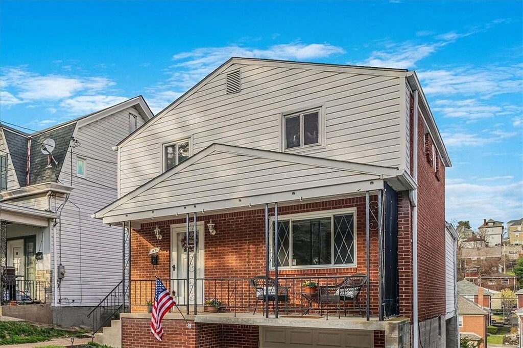 view of front of home featuring covered porch and brick siding