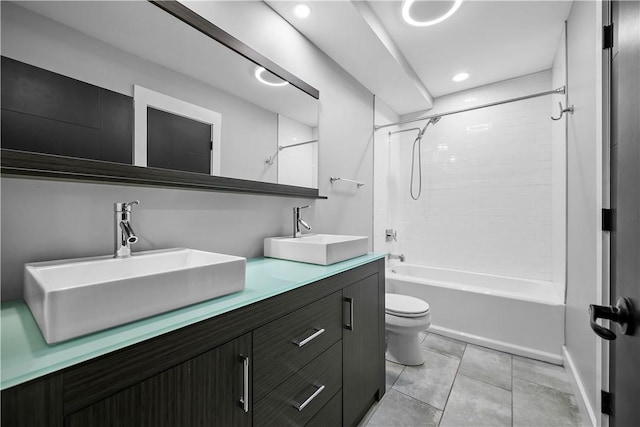 bathroom with bathtub / shower combination, toilet, tile patterned flooring, and a sink