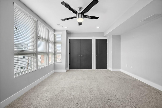 unfurnished bedroom with carpet, a ceiling fan, baseboards, two closets, and recessed lighting