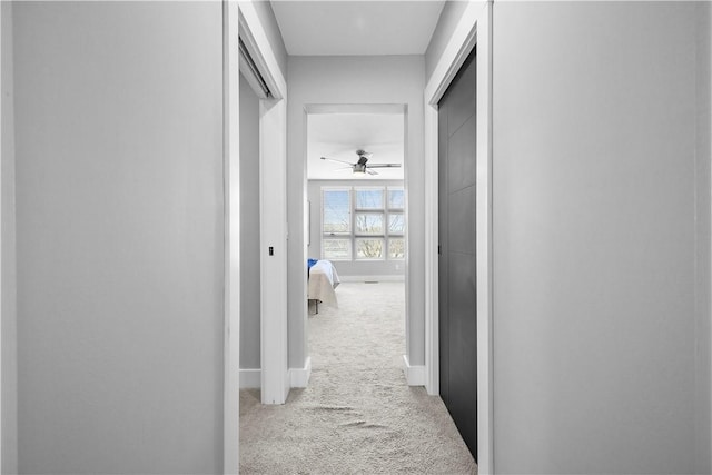 hall featuring carpet flooring and baseboards