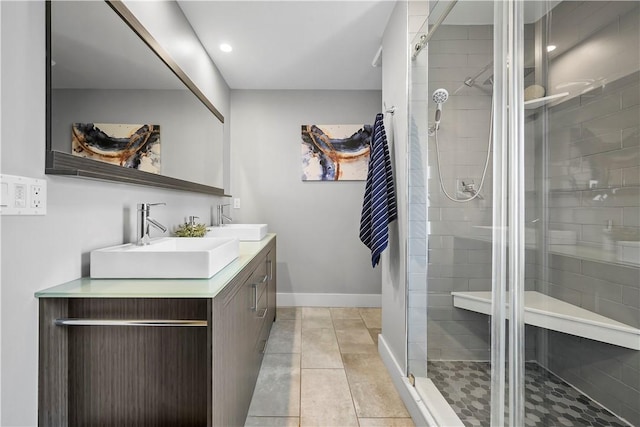full bath with double vanity, a sink, tile patterned flooring, and a shower stall