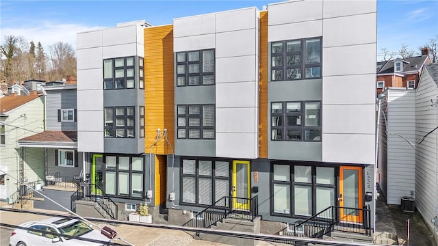 view of front facade featuring stucco siding and central air condition unit