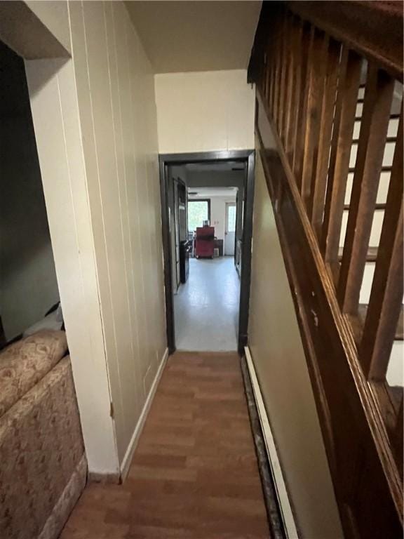 hallway featuring wood finished floors and a baseboard radiator