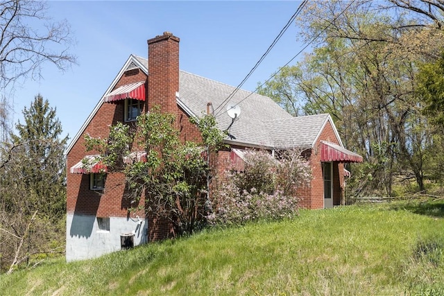 321 Apache Dr, Monessen, PA 15062 - view of property exterior with a chimney, brick siding, and roof with shingles
