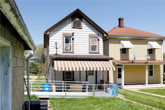 rear view of house featuring a chimney