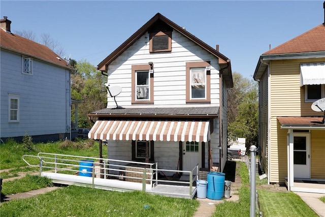 rear view of property featuring a yard