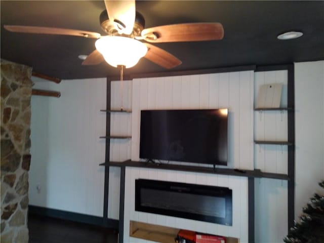 room details featuring a glass covered fireplace and ceiling fan