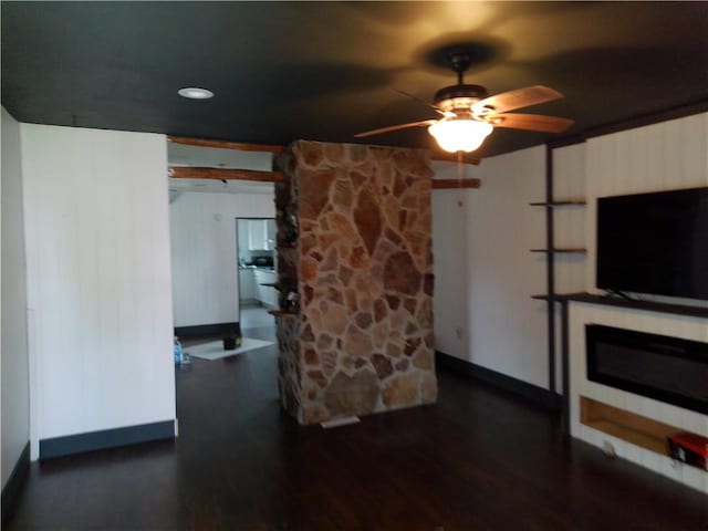 unfurnished living room featuring baseboards, a ceiling fan, wood finished floors, and a fireplace
