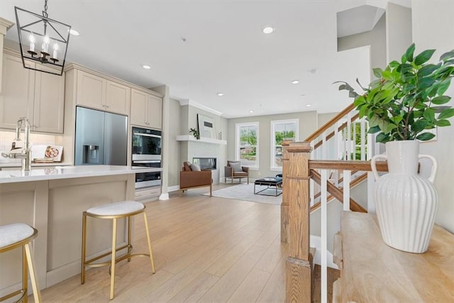 111 Quail Run Rd Unit 1, Peters Twp, PA 15367 - kitchen with stainless steel appliances, light wood-style floors, light countertops, a kitchen breakfast bar, and recessed lighting