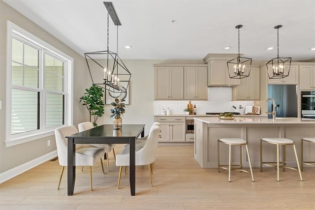 111 Quail Run Rd Unit 1, Peters Twp, PA 15367 - kitchen featuring a chandelier, stainless steel appliances, decorative backsplash, light countertops, and a kitchen breakfast bar