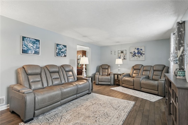 living area featuring visible vents, a textured ceiling, and dark wood-style floors
