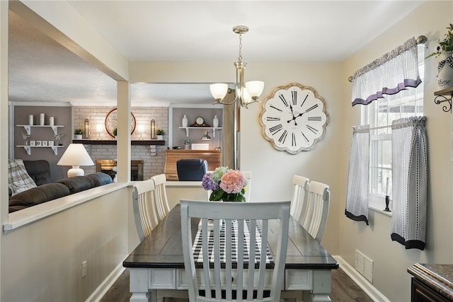 dining room with dark wood finished floors, baseboards, a brick fireplace, and visible vents